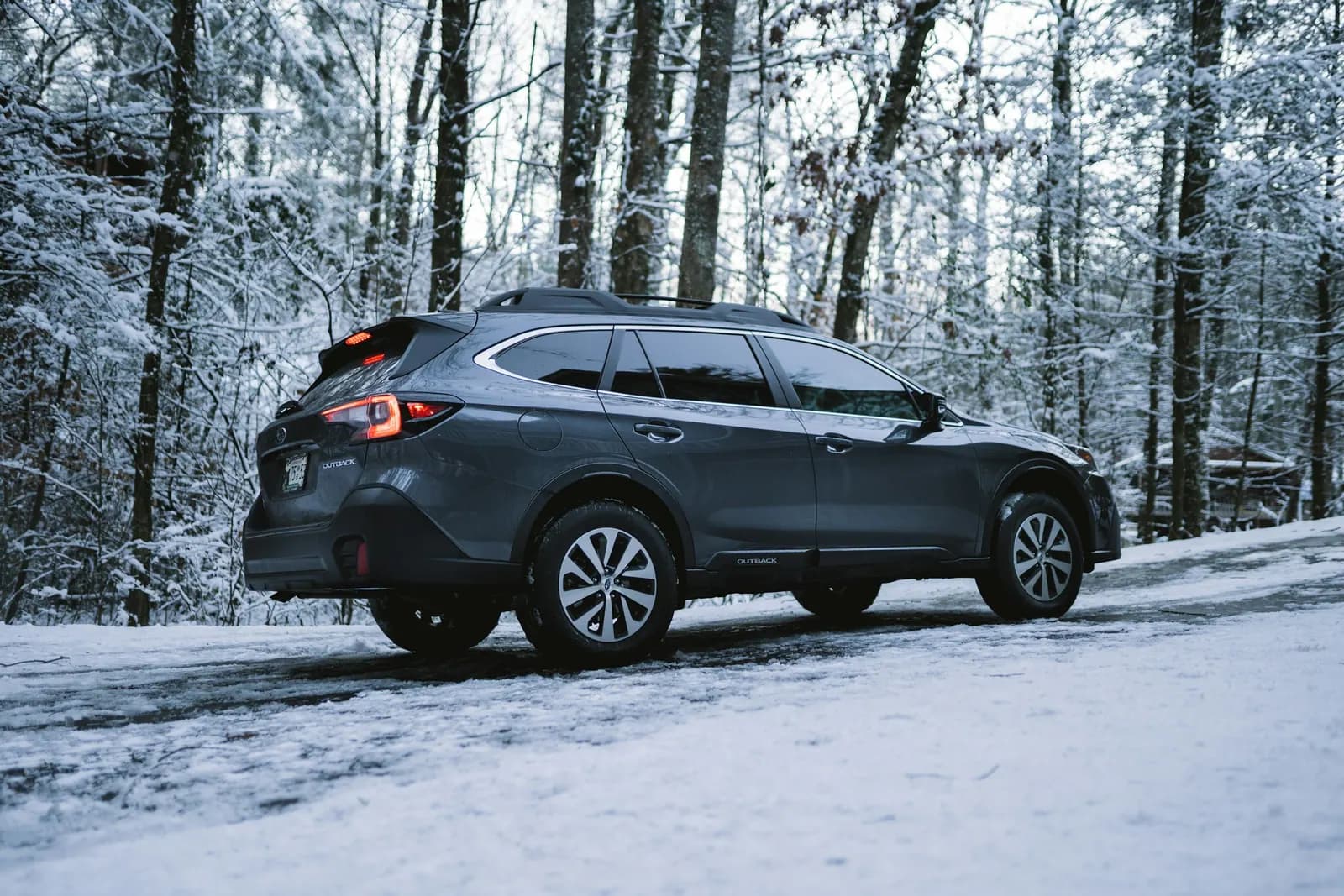 Dark Subaru SUV parked on a snowy forest road